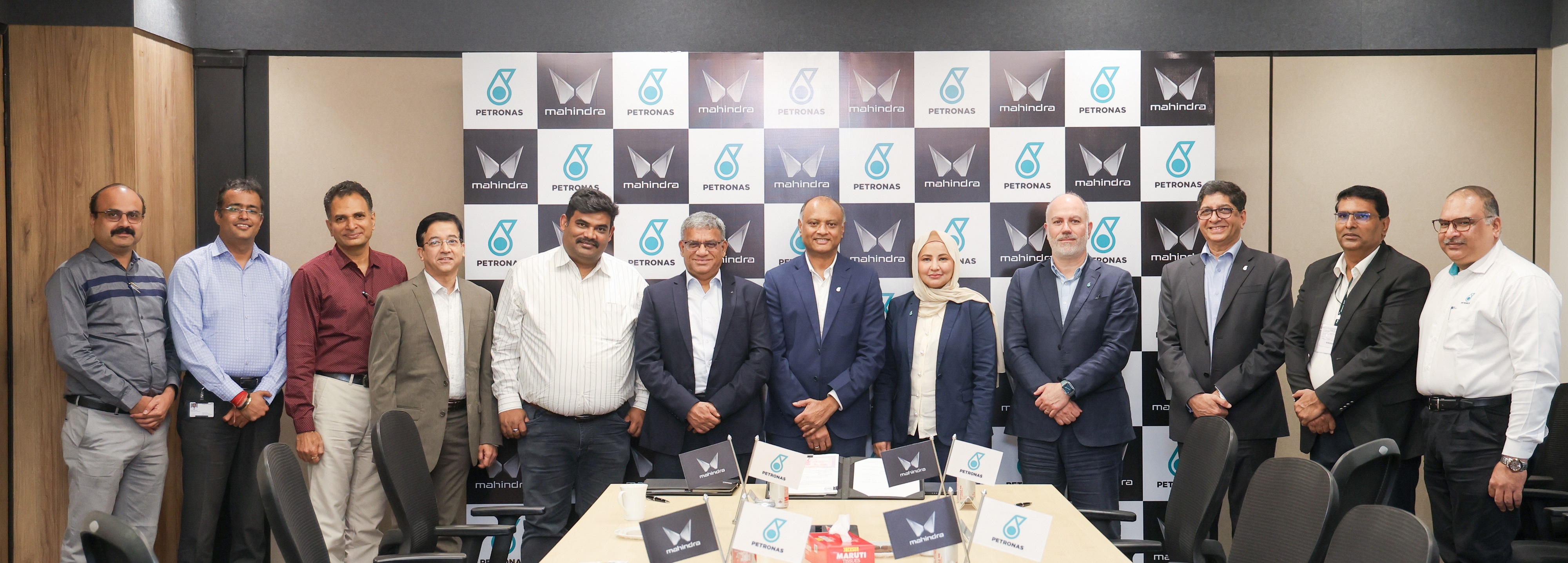 Binu Chandy, Chief Executive Officer of PETRONAS Lubricants India Pvt. Ltd. [7th from Left] and R. Veeraghavan, Senior Vice President Strategic Sourcing, Mahindra & Mahindra Ltd., [6th from Left] accompanied by other PETRONAS Lubricants International and Mahindra representatives at the signing ceremony held in Mumbai on 19 June 2025.​